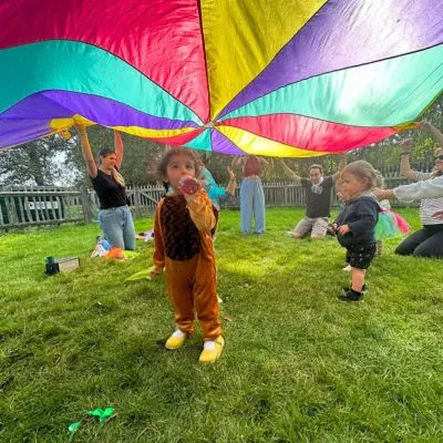 Children playing a parachute game at a Spanish birthday party in London