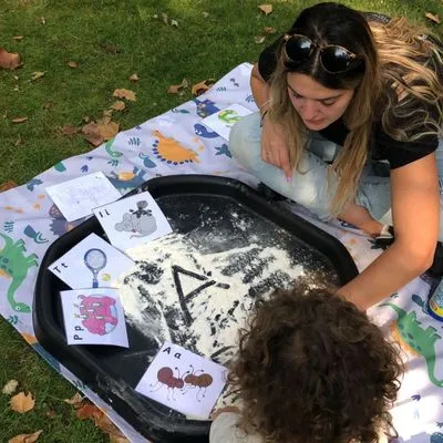 Bilingual child reading and writing in Spanish with a teacher