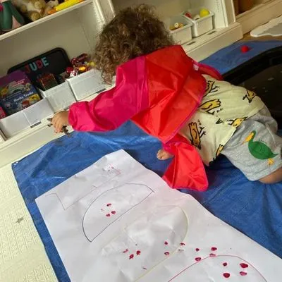 Child painting during a Spanish play session at home